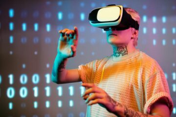 A young man interacts in virtual reality wearing a headset with a digital binary background. (Photo by Darlene Alderson on Pexels)