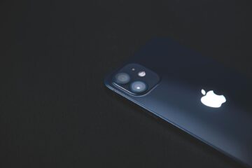 Close-up of a modern smartphone on a dark textured surface, highlighting its sleek design. (Photo by Animesh Srivastava on Pexels)