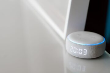 Close-up of a smart speaker with a digital clock display on a minimalist surface. (Photo by Anete Lusina on Pexels)